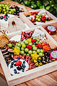 Top view of delicious fresh appetizers on wooden table near green lush shrub