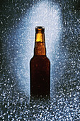 Glasflasche mit kaltem dunklem Bier, umgeben von funkelnden Lichtern auf schwarzem Hintergrund