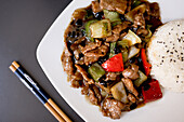 Top view of dish with beef in delicious oyster sauce and chopsticks in restaurant