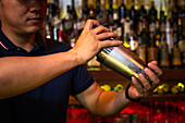 Bartender working with shaker for mixing a cocktail in the bar