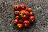 Top view closeup of a pile of red tomatoes on the ground