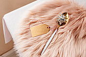 From above christmas table settings with white and golden cutlery with paper tag on pink fluffy placemat