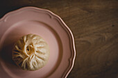 Top view of steamed baozi bun on ceramic plate