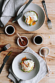 Appetizing slice of grain bread with avocado and poached egg on top placed on plate on wooden table