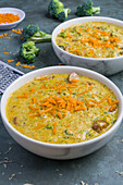 Schalen mit leckerer Suppe mit Brokkoli und Käse auf grauem Tisch in einem Restaurant