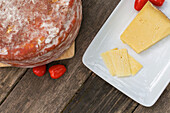 From above delicious Italian Pecorino toscano cheese with cherry tomatoes served on cutting board on wooden table