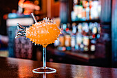 Seitenansicht eines erfrischenden Flavor-Blaster-Cocktails im Glas, serviert auf einem Tresen in einer Bar
