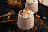 Milkshake with ice vanilla and whipped cream covered with aromatic ground cinnamon in glass