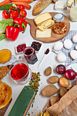 Top view of various healthy food on boards and towels placed on white table