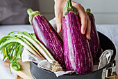 Crop anonymous person preparing vegetable for cooking healthy lunch with green onion in kitchen