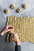 From above crop hand of unrecognizable female rolling fresh dough for pastry in cozy kitchen