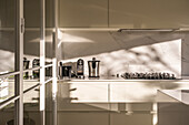 Interieur einer modernen Wohnküche mit hellen Möbeln und Spiegelelementen im Tageslicht