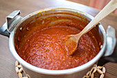 Kochen von Marinara-Sauce aus Tomaten auf dem Herd in der Küche