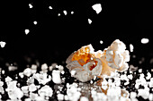 Nahaufnahme eines leckeren Popcorns auf einer Salzschicht