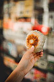 Hands of middle aged holding steamed baozi against blurred background