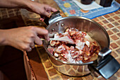 Anonyme Person von oben mit Spachtel, die frische Feigenstücke mit Zucker im Kochtopf vermischt, während sie in der Küche Marmelade zubereitet