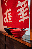 Traditional Asian dish in white ceramic bowl on wooden window in restaurant