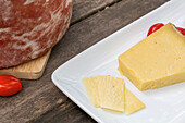 Von oben köstlicher italienischer Pecorino toscano-Käse mit Kirschtomaten auf Schneidebrett auf Holztisch serviert