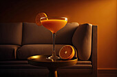 Seitenansicht eines orangefarbenen Cocktailglases auf einem Tisch in einem luxuriösen orangefarbenen Interieur. Generative KI