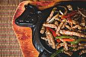 Tasty beef with vegetables placed on black plate