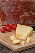 Delicious Italian Pecorino toscano cheese with cherry tomatoes served on cutting board on wooden table