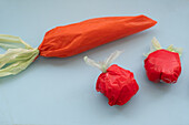 A creative display featuring food items meticulously crafted from colorful plastic bags, presented on a soft blue background, mimicking a quirky meal setup.