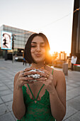 A stylish woman enjoys the sunset in Madrid with the city's iconic Four Towers in the background, showcasing urban Spanish life.