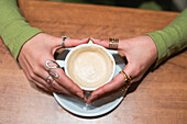 Close-up shot of hands gently holding a warm cup of coffee, creating a sense of comfort and relaxation.