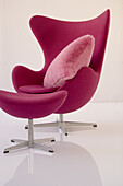 Designer-Sessel in Pink mit passendem Hocker und rosa Kissen