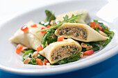 Maultaschen with meat filling on a bed of salad with pine nuts