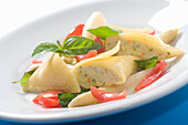 Maultaschen with tomatoes on white asparagus