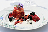 Strawberries in Riesling jelly with berries and cream
