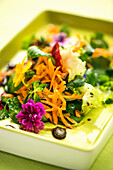 Carrot salad with roasted pumpkin seeds, spinach and flowers