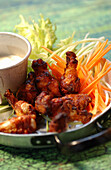 Spicy chicken wings with vegetable sticks and cheese dip