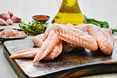 Raw chicken wings on a wooden board with spices
