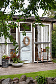 Gemütliches Gartenhaus mit dekoriertem Eingang und Pflanzen