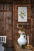 Rustic wooden wall with flower picture, candle and flower vase