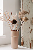 Dried flower bouquet of grasses and pompoms in ceramic vase