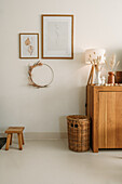 Minimalistically decorated living room with wooden chest of drawers, natural materials and rattan basket