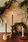 Three burning candles, branches and wreath as Christmas decoration