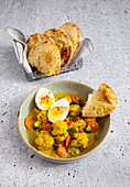 Vegetarian cauliflower curry with eggs and naan bread