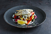 Grilled fish fillet on vegetables with lemon slice