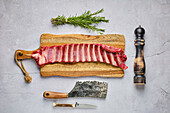 Raw venison ribs on a wooden board with rosemary
