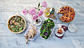 Gedeckter Tisch mit Spinatquiche, Salat und Hefegebäck