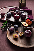 Sliced and whole plums on plates and bowls