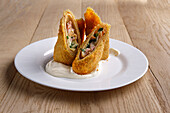 Stuffed and deep-fried pancakes with ham and cheese cream