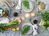 Spring table decoration with ferns, herbs and asparagus