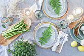 Table setting with fern leaves and asparagus