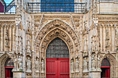 Intricate Gothic architecture and vibrant red doors of Saint Merri Church.