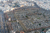 Luftaufnahme des Friedhofs Montparnasse inmitten der Pariser Straßen in der Abenddämmerung.